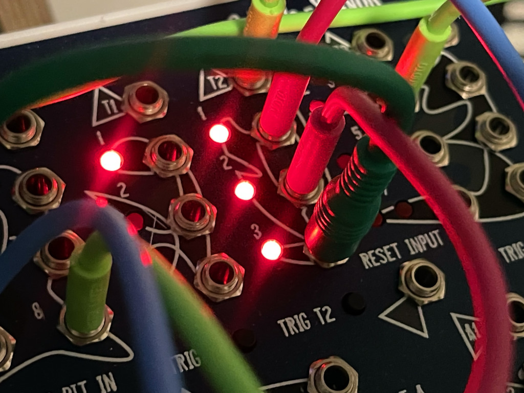 Trigger sequencer, with LEDs lit up, patched - 3-steps and triggers at top, plus reset input jack.