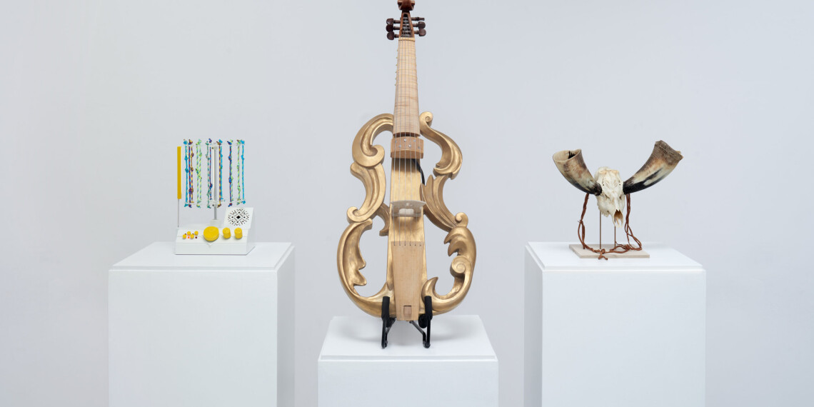 Three speculative designs on white pedestals with a white background. A quipu-powered drum machine with knotted pieces of rope, a viola da gamba with a hollow body and amplification, and a skull-and-bone horn.