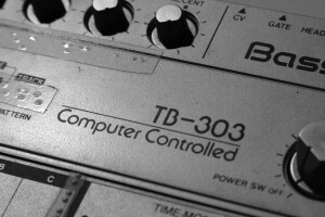 Close-p of vintage TB-303 hardware showing "Computer-Controlled" logo and knobs. "Old Roland TB-303" by Alexandre Dulaunoy is licensed under CC BY-SA 2.0.